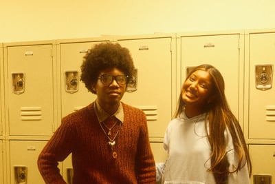 Two students laughing by a row of school lockers